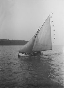 The sailing dinghy 'Hound' with flags, 1912. Creator: Kirk & Sons of Cowes.
