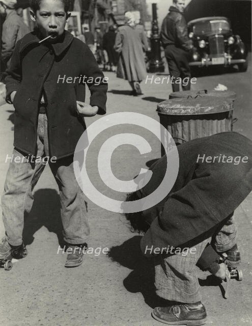 105th Street - Two boys playing with roller skates, each wearing a single roller..., 1947 - 1951. Creator: Romulo Lachatanere.
