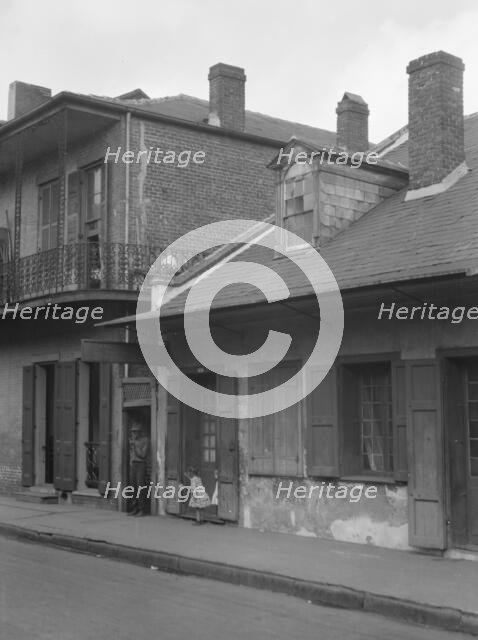 View from across street of two children standing in a doorway in the French Quarter..., c1920-1926. Creator: Arnold Genthe.