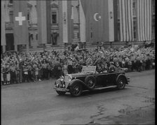 Crowds Watching a Car Drive Through Berlin, 1936. Creator: British Pathe Ltd.