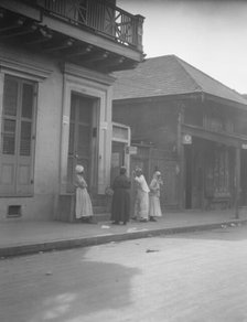 View from across street of four women talking, New Orleans, between 1920 and 1926. Creator: Arnold Genthe.
