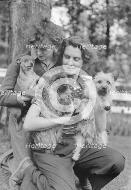 Le Gallienne, Eva, and unidentified woman, with dogs, outdoors, 1937 Creator: Arnold Genthe.