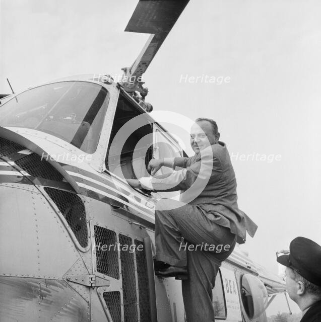 P.A. Gaglardi, Minister of Highways for British Columbia, climbing into a helicopter, M1, 22/5/1959. Creator: John Laing plc.