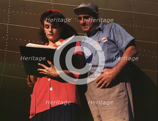 Girl inspector confers with a worker as she..., Douglas Aircraft Company, Long Beach, Calif., 1942. Creator: Alfred T Palmer.