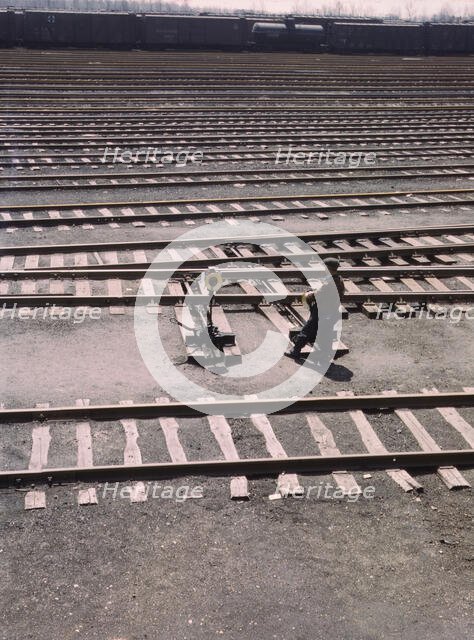 Switchman throwing a switch a C and NW RR's Proviso yard, Chicago, Ill., 1943. Creator: Jack Delano.