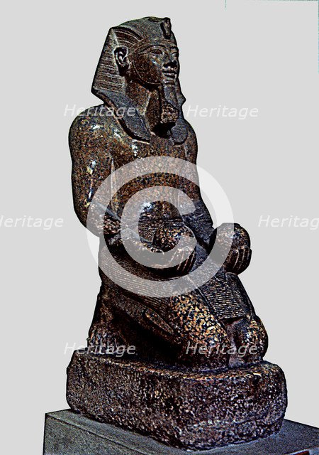 Amenhotep II offering two glasses of wine to a god, statue made in red granite.
