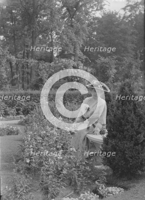 Truesdale, W., Mrs., standing in a garden, 1915 July 6. Creator: Arnold Genthe.