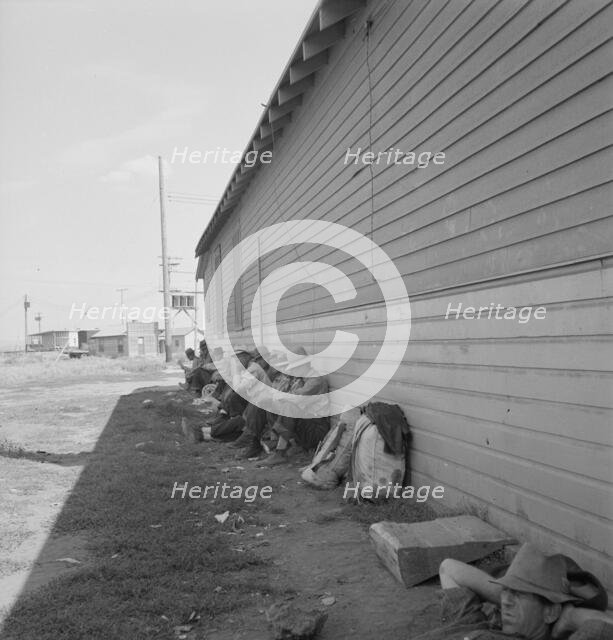 Possibly: Idle men seated in shade on the other side..., Tulelake, Siskiyou County, California, 1939 Creator: Dorothea Lange.