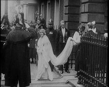 The Duke of York and Lady Elizabeth Bowes-Lyon Emerging from a House on Their Wedding Day, 1920. Creator: British Pathe Ltd.