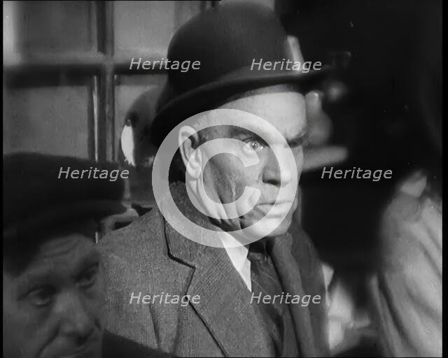 Scene from the Film 'The Informer':  Male Actor Looking at Money Being Thrown on the..., 1920s. Creator: British Pathe Ltd.