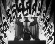 German Eagle Statue With German Flags Behind Bearing the Nazi Swastika, 1937. Creator: British Pathe Ltd.