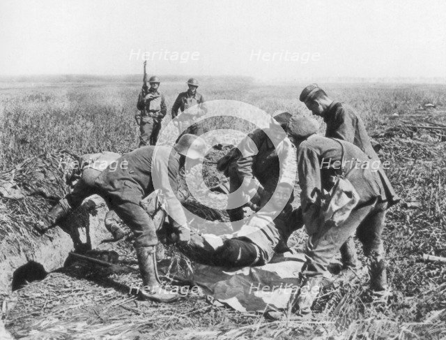 Wounded German soldier being moved by prisoners, Aisne, France, 18 July, 1918. Artist: Unknown