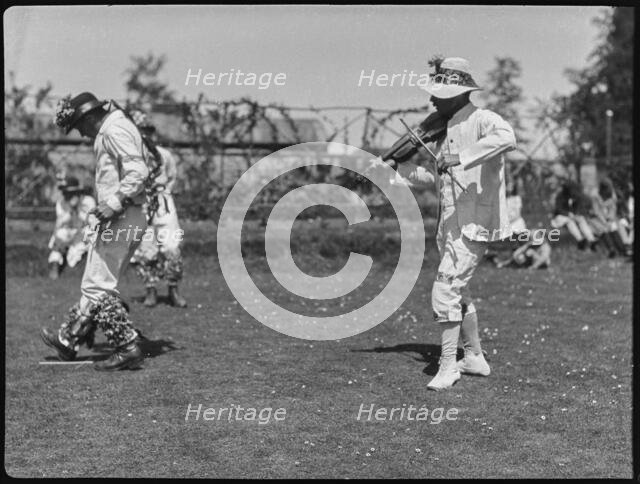 Bampton Morris troupe performing in a 'Pipe Dance', with a fiddle player,  Oxfordshire, 1920-30.  Creator: George R Long.