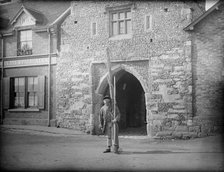 A shrimper with his equipment standing in front of Old Fishers Gate, Sandwich, Kent, c1860-c1922. Artist: Henry Taunt