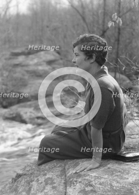 DeLamar, Alice, Miss, seated on a rock, between 1927 and 1942. Creator: Arnold Genthe.