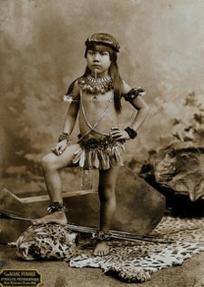 A child of an Amazonian Indian tribe, standing on a leopard skin, in a photographic studio, 1900. Creator: Unknown.