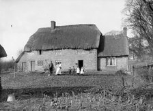 A family pose outside their thatched cottage at Hatford, Oxfordshire, c1860-c1922. Artist: Henry Taunt
