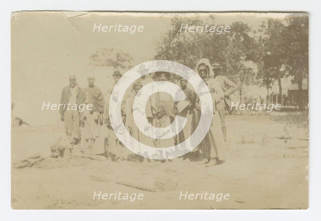 Photograph of men, women, and children in a yard, early 20th century. Creator: Unknown.