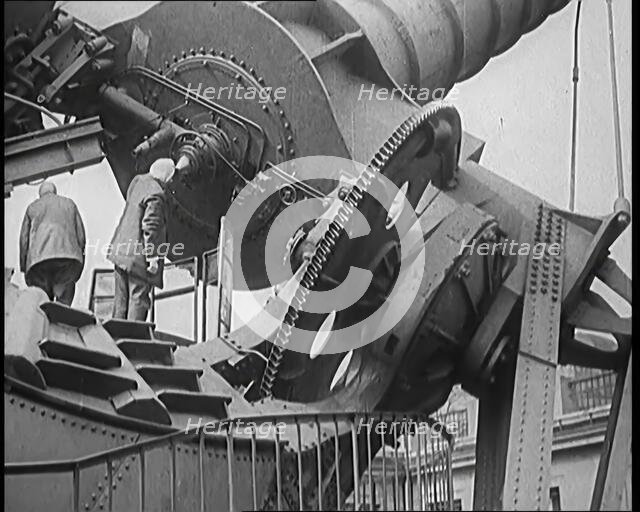 Large Telescope Being Turned by Two Civilians, 1931. Creator: British Pathe Ltd.