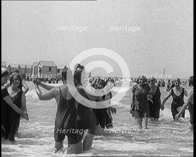 Civilians Wearing Swimsuits Enjoying a Sunny Day Dancing at a Very Crowded Beach, 1920. Creator: British Pathe Ltd.