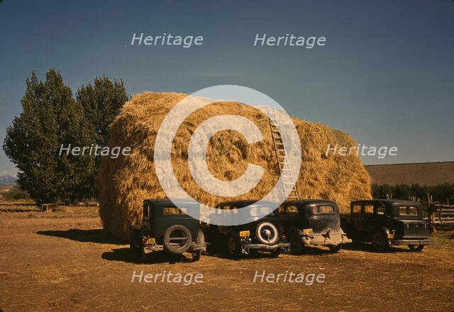Hay stack and automobile of peach pickers, Delta County, Colorado, 1940. Creator: Russell Lee.