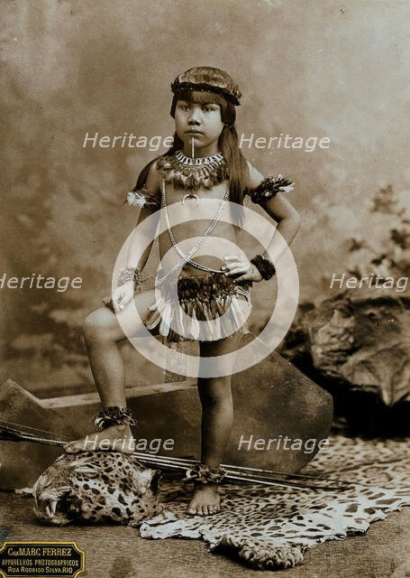 A child of an Amazonian Indian tribe, standing on a leopard skin, in a photographic studio, 1900. Creator: Unknown.