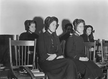Visiting lassies sit on rostrom, Salvation Army, San Francisco, California, 1939. Creator: Dorothea Lange.