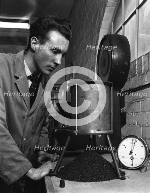 A lab technician undertaking a coal flow test, Mapperley Colliery, Derbyshire, 1962.  Artist: Michael Walters