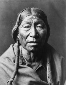 Cheyenne male, facing front, hair in wrapped braids, blanket around shoulders, c1910. Creator: Edward Sheriff Curtis.