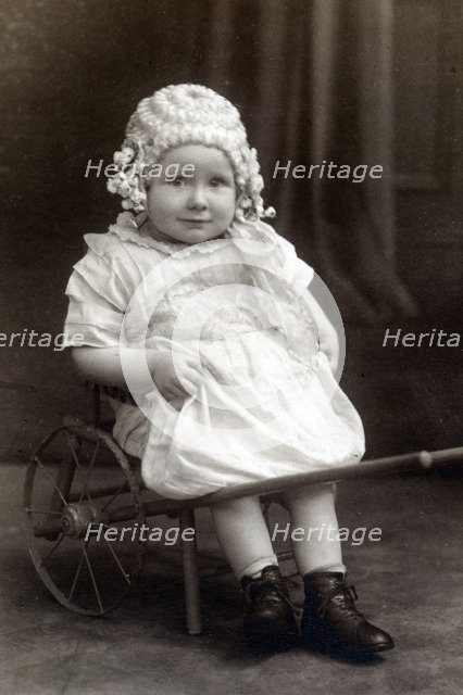 A little girl in a cart, c1910. Artist: Unknown