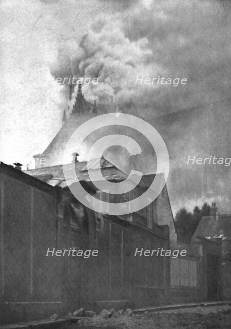 ''Le Cathedrale de Reims en flammes; Le clocher a l'Ange et la toiture du chevet en feu', 1914. Creator: T Holden Waterhouse.