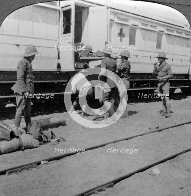 Lifting wounded soldiers onto a hospital train, East Africa, World War I, 1914-1918.Artist: Realistic Travels Publishers
