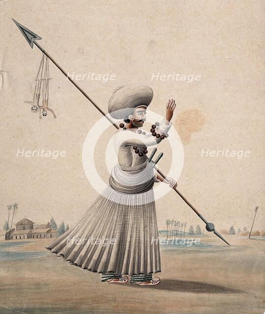 A man holding a long arrow with two puppets (?) hanging from it, (between 1800 and 1899?). Creator: Unknown.