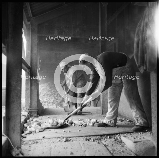 Men shovelling flint in a flint calcinating kiln, WJ Dolby works, Stoke-on-Trent, 1965-1968. Creator: Eileen Deste.