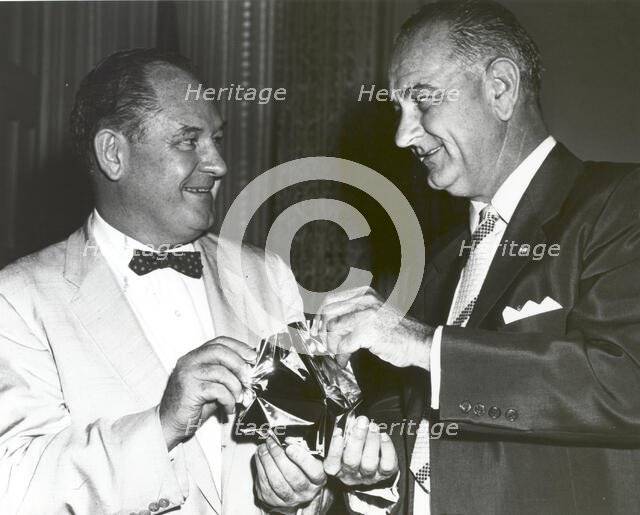 T. Keith Glennan shows Lyndon Johnson aluminized mylar flim used to make the Echo I balloon, 1960.. Creator: NASA.