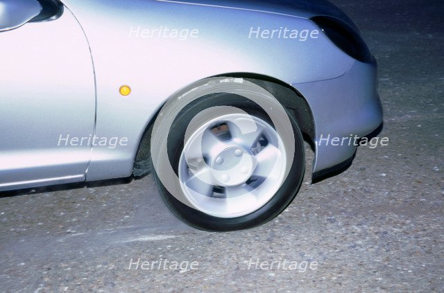 Wheel spin on 1998 Ford Puma producing smoke. Artist: Unknown.