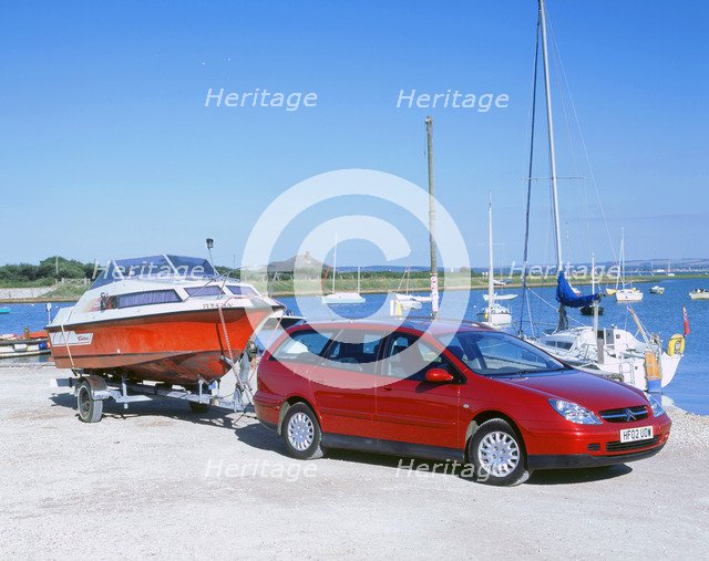 2002 Citroen C5 hdi towing a boat by harbour. Artist: Unknown.