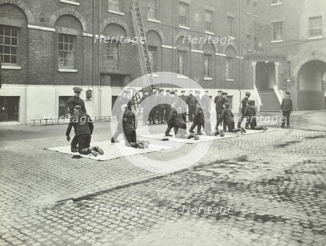 Demonstrating how to pick up an unconscious person, London Fire Brigade Headquarters, London, 1910. Artist: Unknown.