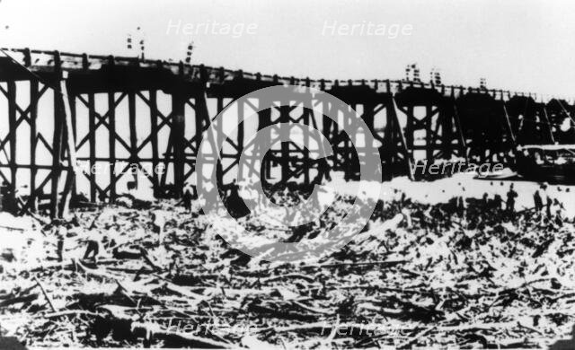 Workers below Victoria Bridge, cleaning up debris after the flood, Brisbane, 1893. Creator: Unknown.
