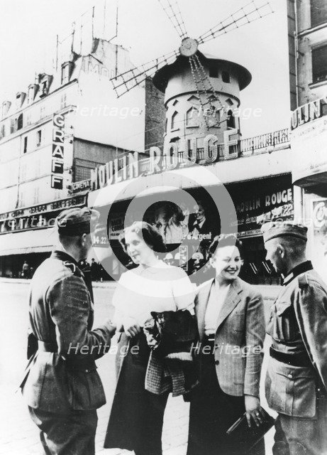 German soldiers chatting up French women outside the Moulin Rouge, occupied Paris, June 1940. Artist: Unknown