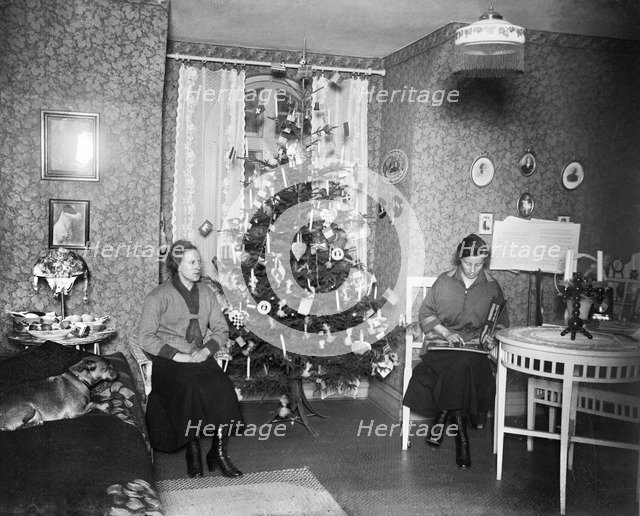 Two women on Christmas Eve with a Christmas tree in front of the window, Sweden, early 1900s. Artist: Unknown