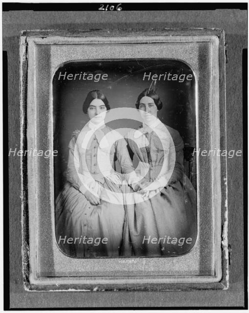 Two unidentified women, three-quarter length portraits, seated, between 1851 and 1860. Creator: H. R. Marks.