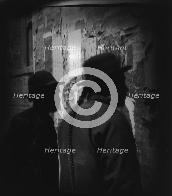 Reading wall notices, Chinatown, San Francisco, between 1896 and 1906. Creator: Arnold Genthe.