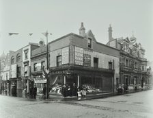 Shops and sign to Putney Roller Skating Rink, Putney Bridge Road, London, 1911. Artist: Unknown.