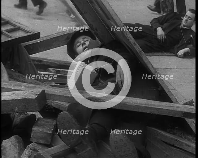 British People Acting Out Bomb attacks and Crashed German Planes, Lying Under Rubble, 1940. Creator: British Pathe Ltd.