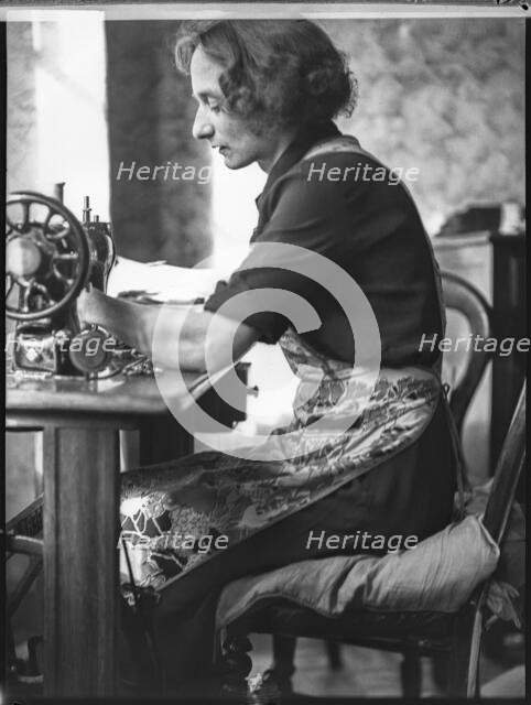 A glover or glove maker working at a sewing machine, Woodstock, Oxfordshire, 1920-1940.  Creator: George R Long.