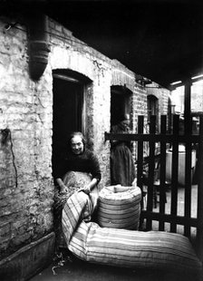 Ma Rolinson of Bethnal Green making mattresses, c1890-c1907. Artist: Unknown