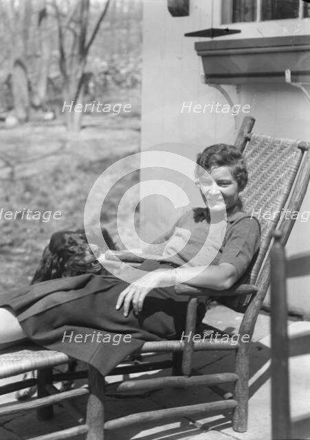 DeLamar, Alice, Miss, with dog, seated outdoors, between 1927 and 1942. Creator: Arnold Genthe.