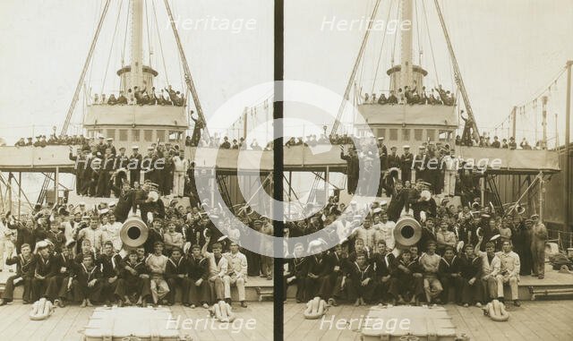 Sailors, probably American, and some civilians posed on a cruiser berthed in New York(?), c1905. Creator: Underwood & Underwood.