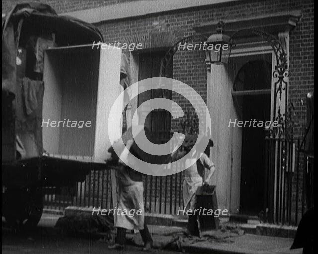Two Male Civilians Load Furniture Into a Van Outside of 10 Downing Street, 1924. Creator: British Pathe Ltd.